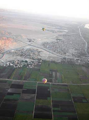 Several Balloons float along below us as we fly above the West Bank of Luxor, Egypt